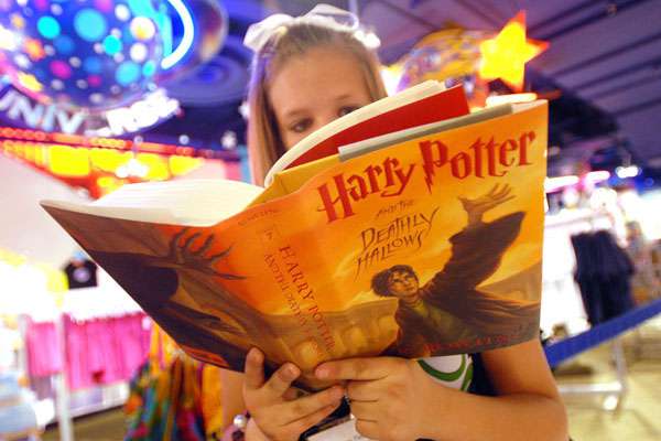 girl reading Harry Potter And The Deathly Hallows book img
